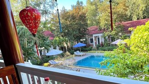 Comedor con vista a la piscina, mobiliario exterior y faroles decorativos.