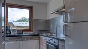 Una cocina moderna con lavavajillas Bosch, un lavamanos y un refrigerador de acero inoxidable.