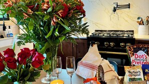 A kitchen counter with a floral arrangement, wine glasses, a candle, and a charcuterie board. -  Newly remodeled-Lakefront cabin on 4th Lake w/dock & kayaks. Trail 5 Access (Old Forge)