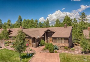 A two-story house with a front porch, a driveway, and a well-maintained lawn.