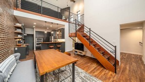 Ein modernes Loft mit Küche, Essbereich und einer Treppe.