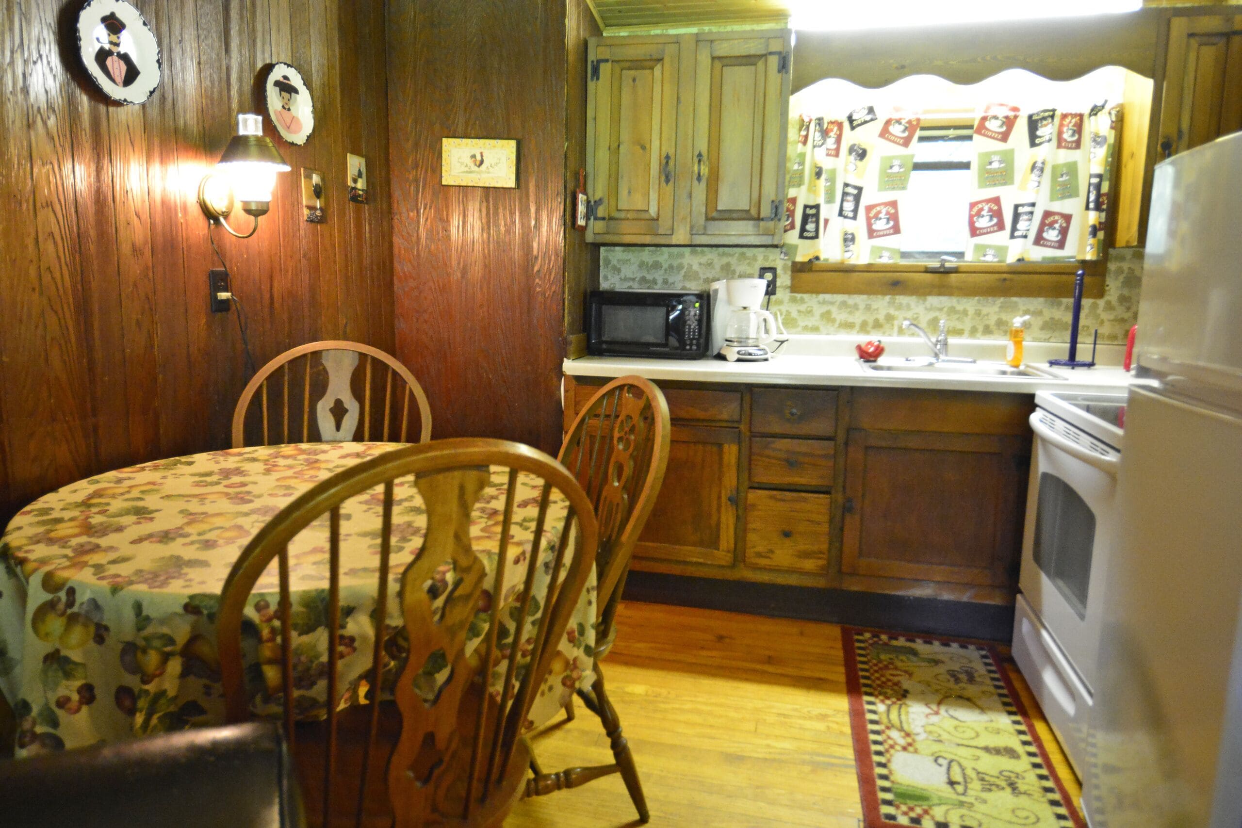 A kitchen with wooden cabinets, a microwave, a coffee maker, and a refrigerator.