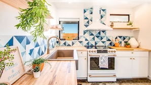 Una cocina moderna con un ventanal grande, un salpicadero geométrico y vistas al exterior.
