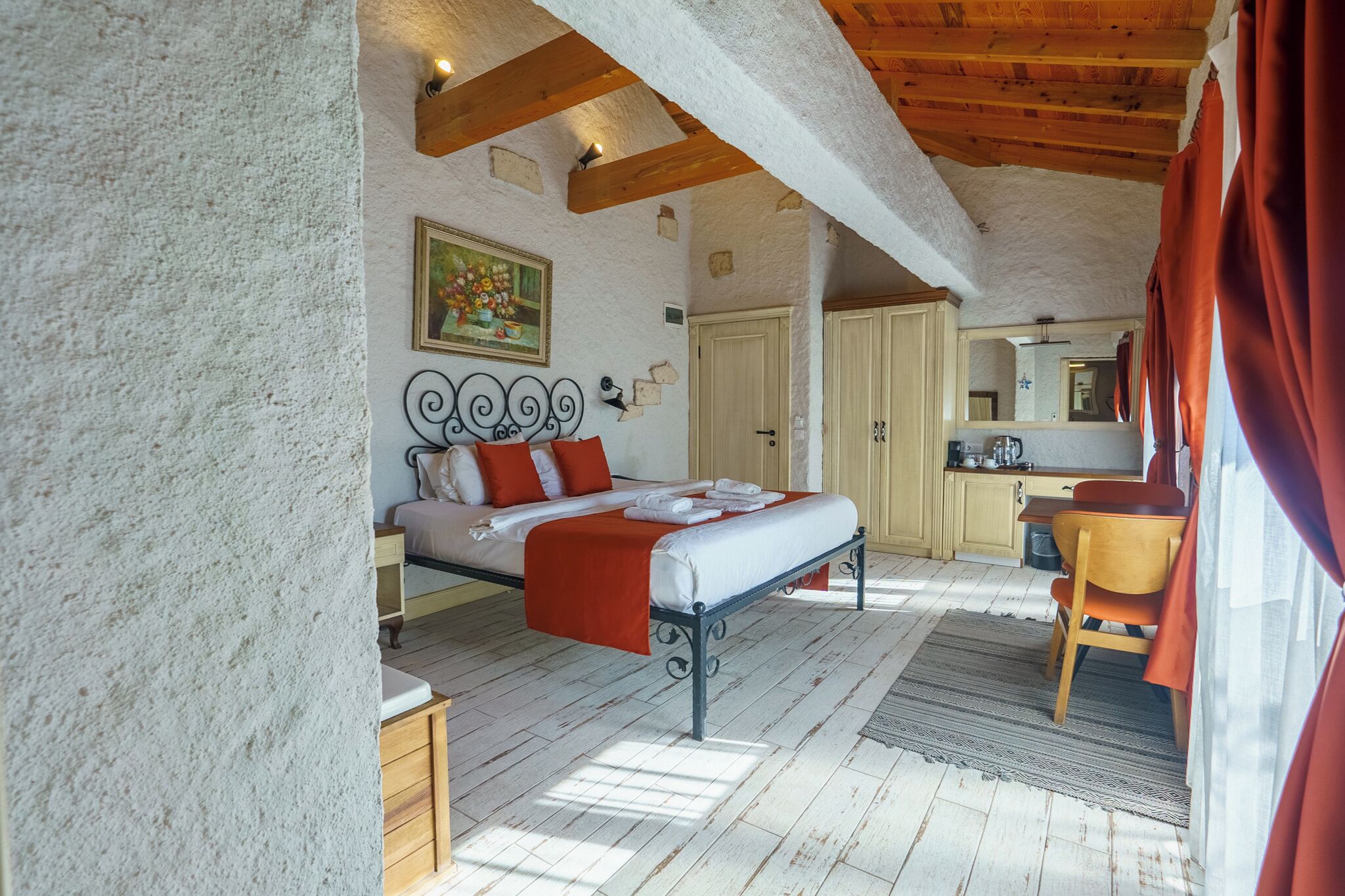 Un dormitorio con una cama, una silla de madera, una mesa de comedor y una zona de cocina.