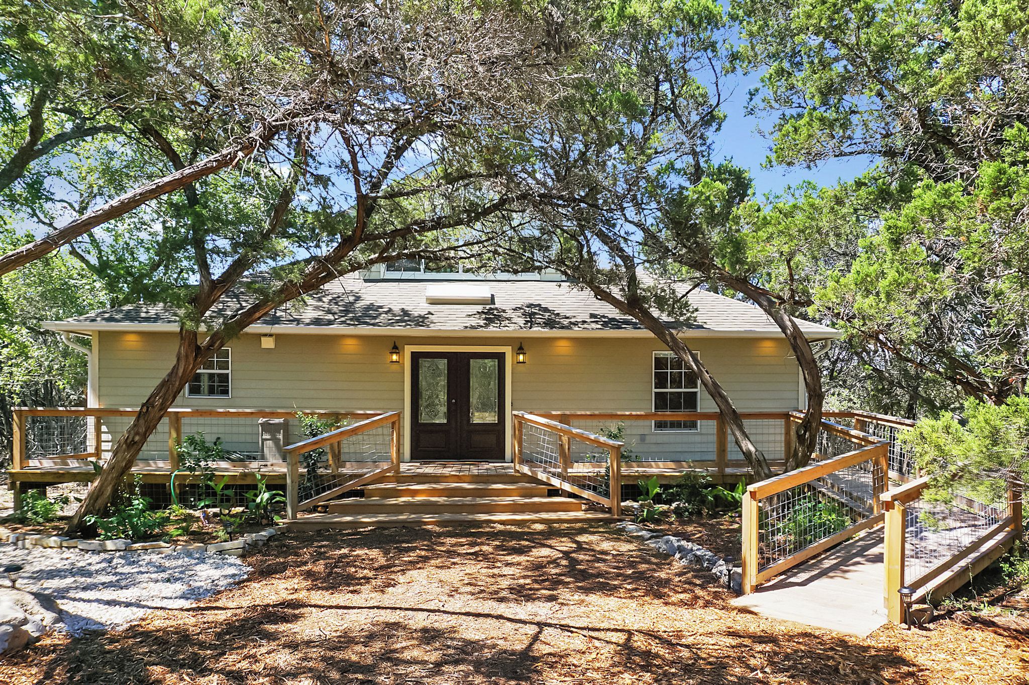 A house with a wooden deck, a front door, and a small porch area.