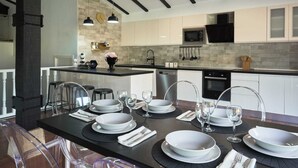 A modern kitchen with a central island, stainless steel appliances, and a stone backsplash.