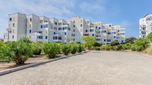 A modern apartment complex with multiple buildings, a paved driveway, and green landscaping. - Apartment Estany by Interhome (Le Barcarès)