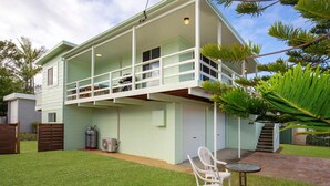 Ein zweistöckiges Haus mit Balkon, Garage und kleiner Terrasse.