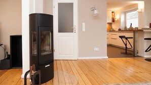 A modern kitchen with wooden flooring, a built-in stove, and a white door. - Mitte 6, Deutschland (Hörnum (Sylt))