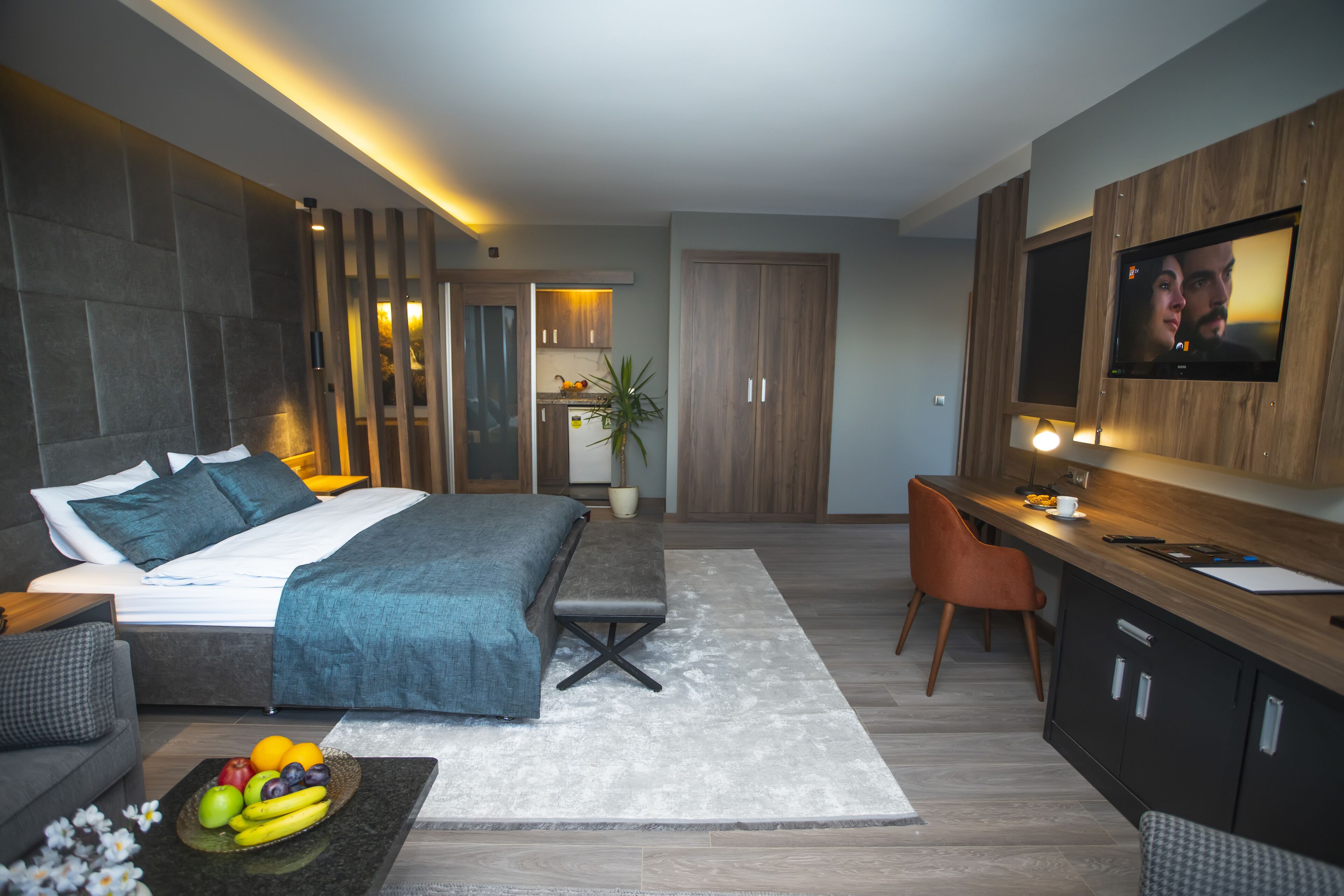 A modern bedroom with a bed, bedside table, and a fruit bowl.