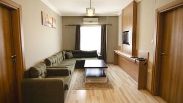 Una sala de estar moderna con un sofá modular, una mesa de centro y un televisor de pantalla plana montado en la pared.