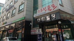 A multi-story building with a prominent glass facade and several commercial signs. - Noble Residence (Seoul)