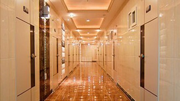 A long, well-lit hallway with shiny tiled floors and doors on both sides. - Noble Residence (Seoul)