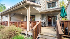 Une maison à deux étages dotée d’un porche couvert, d’une terrasse et d’une porte d’entrée donnant sur un garage.