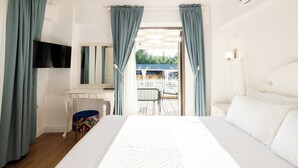 A bedroom with a bed, a desk, a chair, and a TV. - Fitoz Otel (Bozcaada)