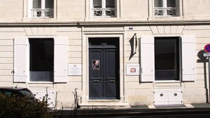 Un immeuble à plusieurs étages, de style architectural classique, caractérisé par des fenêtres disposées de manière symétrique et une entrée centrale.