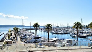 A marina with numerous boats docked, a clear sky, and palm trees. - Air-conditioned 1BR apartment with parking in Cavalaire-sur-Mer (Cavalaire-sur-Mer)