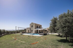 A building with a pool, outdoor seating, and a view of the landscape.