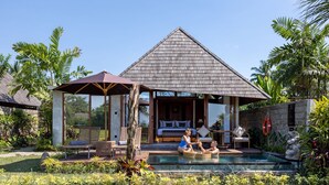 A resort with a pool, outdoor seating, and a covered area with a bed. - Lasamana Villas Ubud by GenuineHost (Ubud)