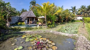 A tropical resort with a pool, a small house, and lush vegetation. - Lasamana Villas Ubud by GenuineHost (Ubud)