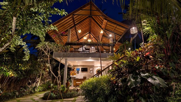 A two-story wooden structure with a balcony, surrounded by lush tropical vegetation. - Lasamana Villas Ubud by GenuineHost (Ubud)