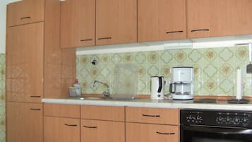 Een koelkast, een oven, een kookplaat, een koffiezetapparaat/waterkoker