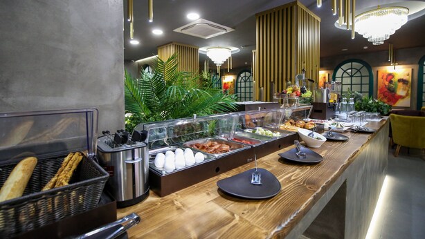Un buffet garni de divers plats, une plante et un lustre.