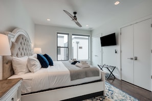 Relax in this serene bedroom with a large bed, ceiling fan, and flat-screen TV.