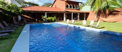 Alberca al aire libre y camastros