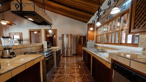 Una cocina con isla central, electrodomésticos de acero inoxidable y suelo de baldosas estampadas.