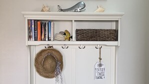 En hvid bænk med pude, hvor der står "mermaid kisses & starfish wishes", og et skilt over den med teksten "BEACH ACCESS".