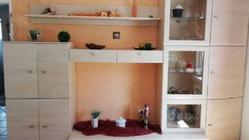 Eine Küche mit einer Uhr, Schränken, Regalen und einer Vitrine.