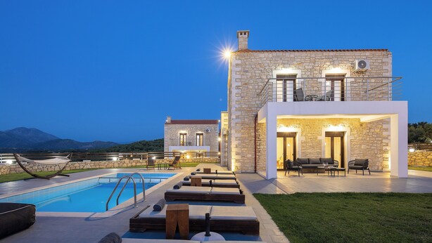 A modern villa with a swimming pool, outdoor seating, and a stone facade. - Dimokritos Villa V, Family Stay with Lawn & Play (Aggeliana, Rethymno)