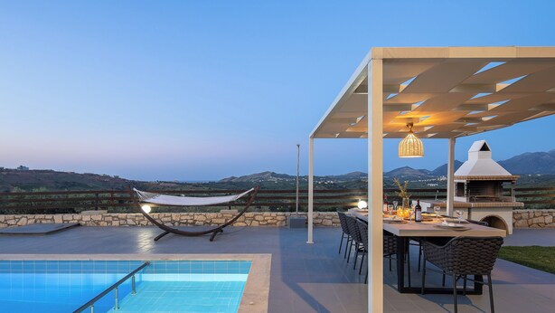 Area piscina con amaca, mobili da esterno e barbecue.