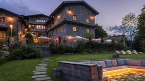 Un edificio de piedra con un amplio espacio de terraza y un césped bien cuidado.