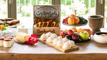 Una mesa de buffet con diferentes opciones de comida, incluyendo pan, queso, fruta y postres.