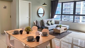 A modern living room with a dining area, a sofa, and a view of a cityscape through large windows. - ARTE PLUS - COZY & COMFORTABLE (PVT LIFT)  (Kuala Lumpur)