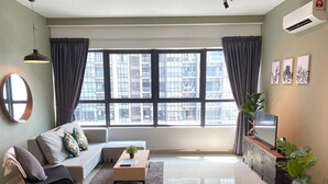 A modern living room with a sofa, dining table, and TV. Large windows offer a city view. - ARTE PLUS - COZY & COMFORTABLE (PVT LIFT)  (Kuala Lumpur)