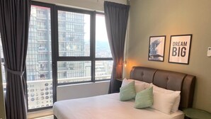 A hotel room with a large bed, a view of the city through a window, and two framed pictures on the wall. - ARTE PLUS - COZY & COMFORTABLE (PVT LIFT)  (Kuala Lumpur)