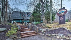 A wooden staircase leading to a building with a sign for Big Bass Lake Community Association. - Classic Cabin in Pocono Mountain Resort (Gouldsboro)