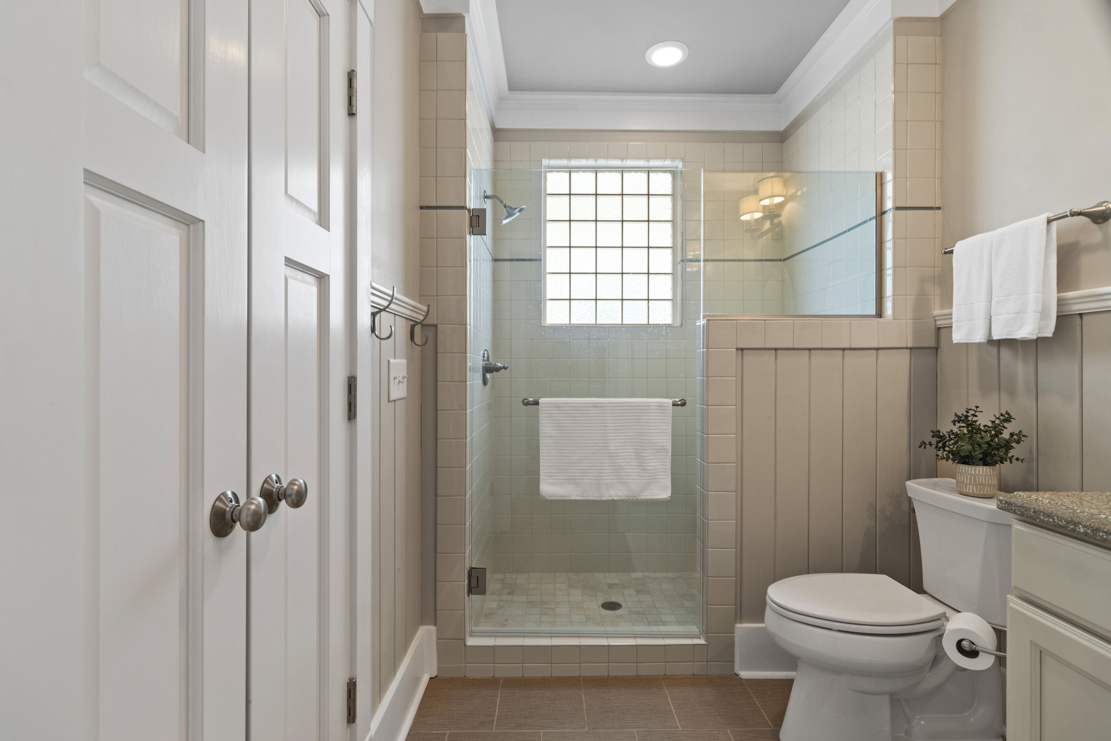 Un bagno con doccia vetrata, un water e un lavandino.