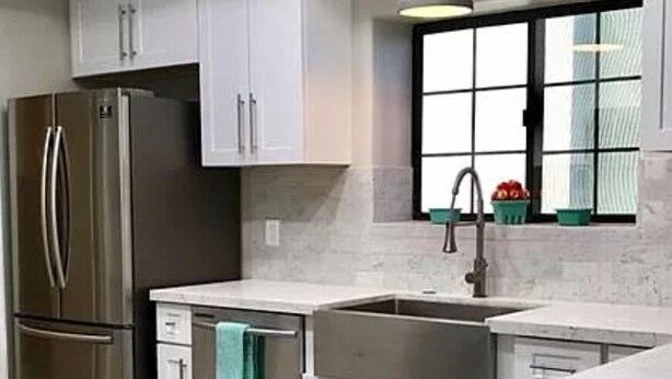 A modern kitchen with white cabinets, stainless steel appliances, and a window with a view. - Bullhead oasis! Enjoy putt putt, view, pool & heated spa! (Bullhead City)