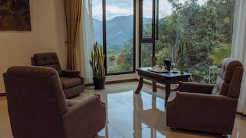 Chambre Triple Luxe | Coin séjour | TV connectée de 32 pouces avec chaßnes par cùble, télévision