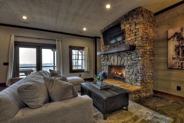 A living room with a stone fireplace, a sofa, and a coffee table.