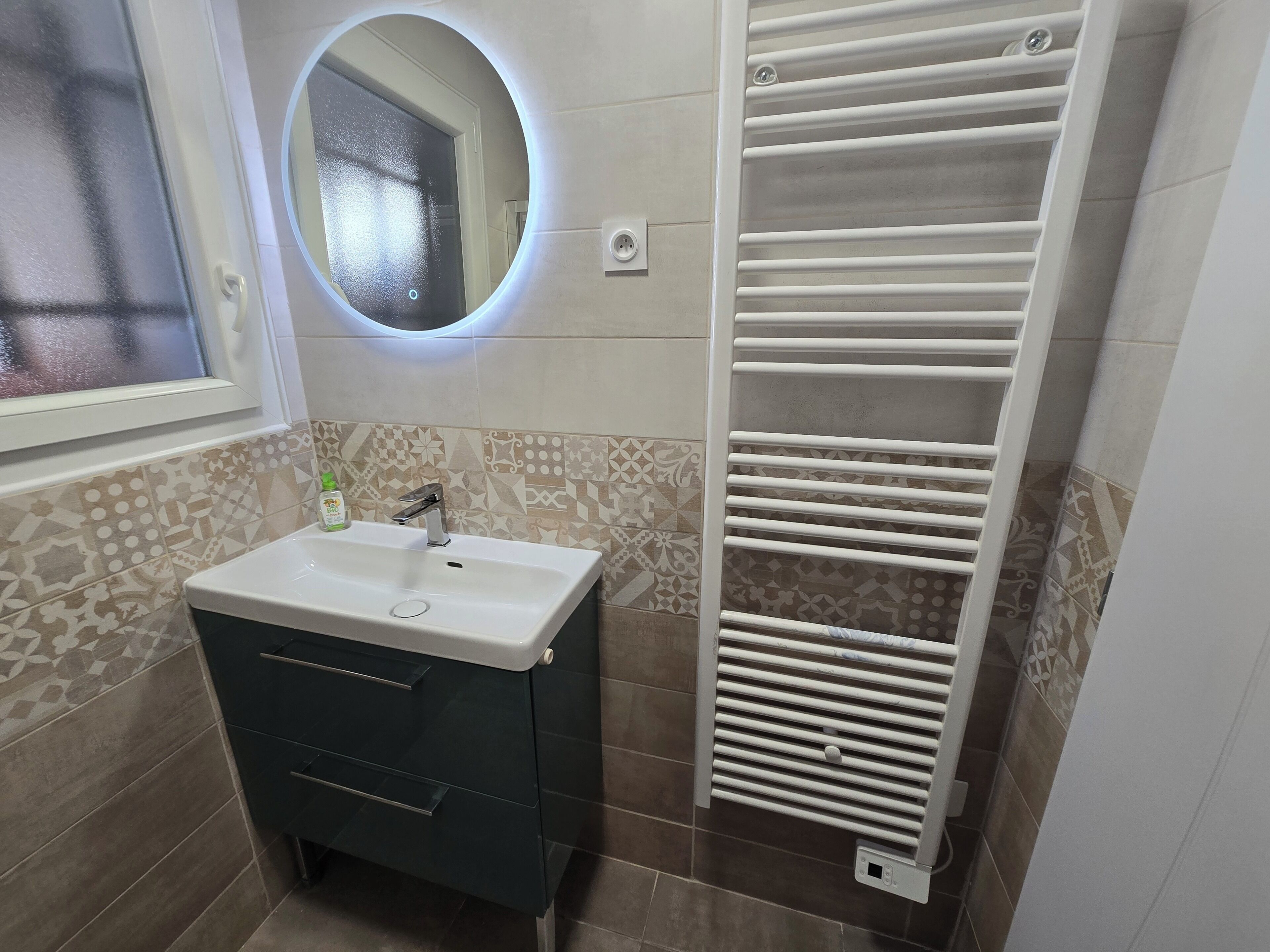 A bathroom with a sink, mirror, and towel rack.