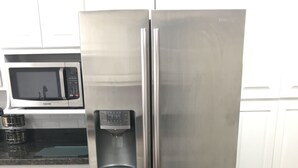 A stainless steel refrigerator with a water dispenser, a microwave above it, and white cabinets in the background. - Casa de La Cruz - 3BR 3BA -w/ Plasma Air Technology 2,200sf Sleeps 10  (El Paso)