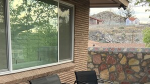 A patio with a brick wall, a stone wall, and a window. - Casa de La Cruz - 3BR 3BA -w/ Plasma Air Technology 2,200sf Sleeps 10  (El Paso)