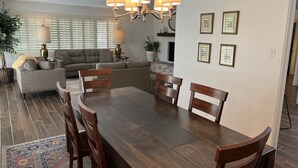 A dining area with a dark wood table, four wooden chairs, and a chandelier. - Casa de La Cruz - 3BR 3BA -w/ Plasma Air Technology 2,200sf Sleeps 10  (El Paso)