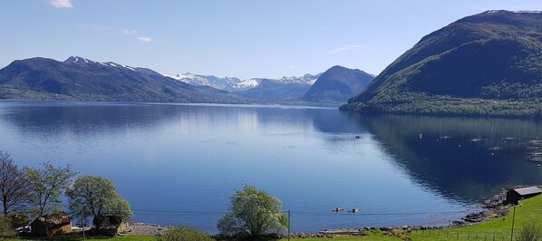 A calm lake surrounded by mountains with clear skies. - Irenegarden (Volda)