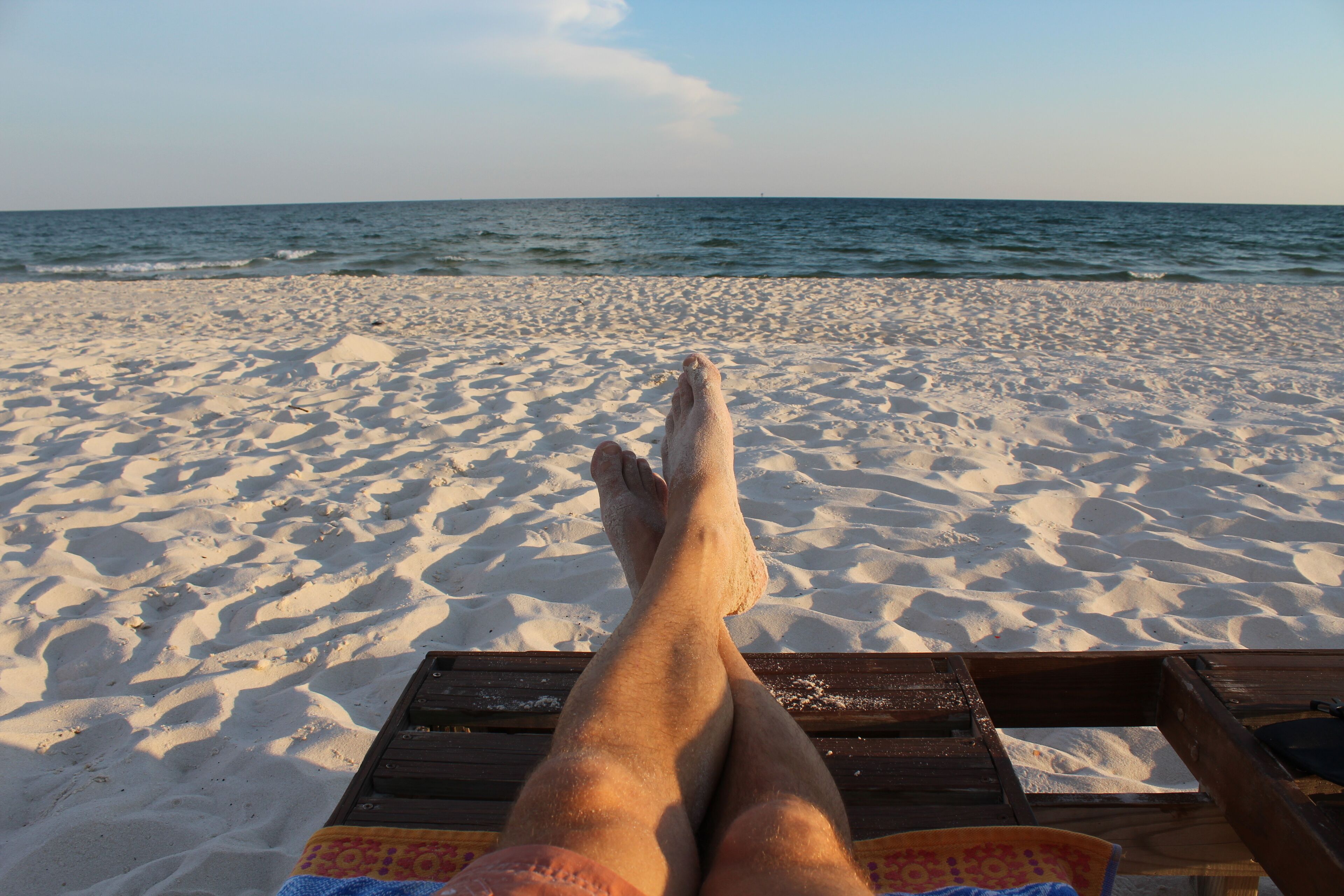Una playa con una terraza de madera y vista al océano.